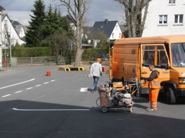 Foto vom Mann bei der Arbeit mit der Straßenmarkierungsmaschine