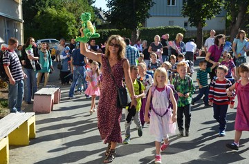 Foto der Klassenlehrerin mit den Kindern der neuen Klasse 1a auf dem Weg zum Klassenraum