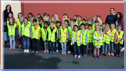 Gruppenbild aller Erstklässler in ihren gelben Warnwesten mit ihren Klassenleitungen und der Anmeldemutter